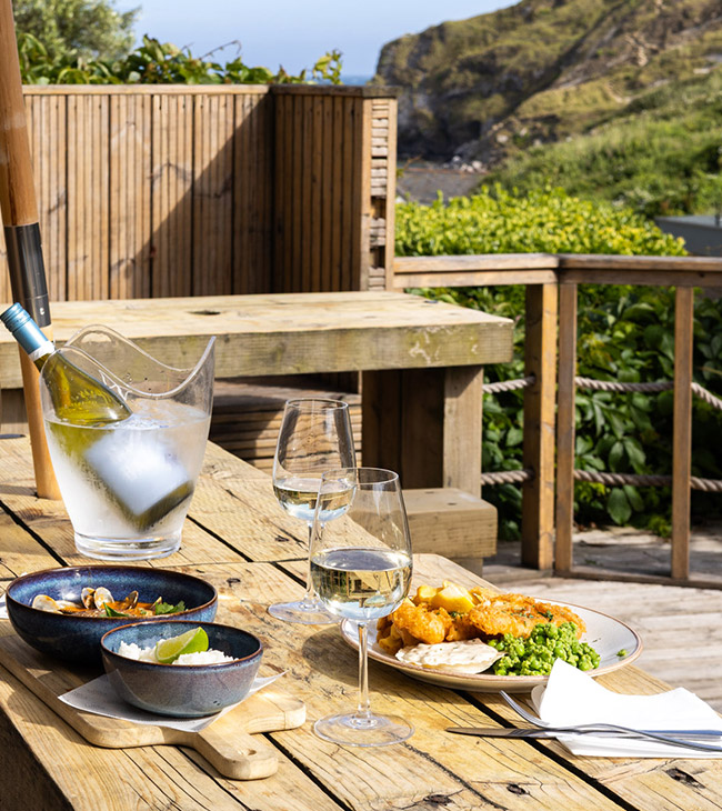 Enjoy outdoor dining at The Lodge at Lulworth, with sea views, a sun-soaked terrace, and fresh Dorset food served by the coast.